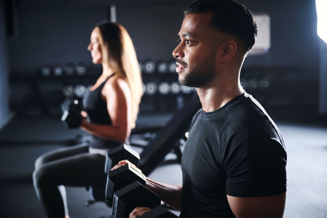 Frau und Mann beim Krafttraining mit Kurzhanteln